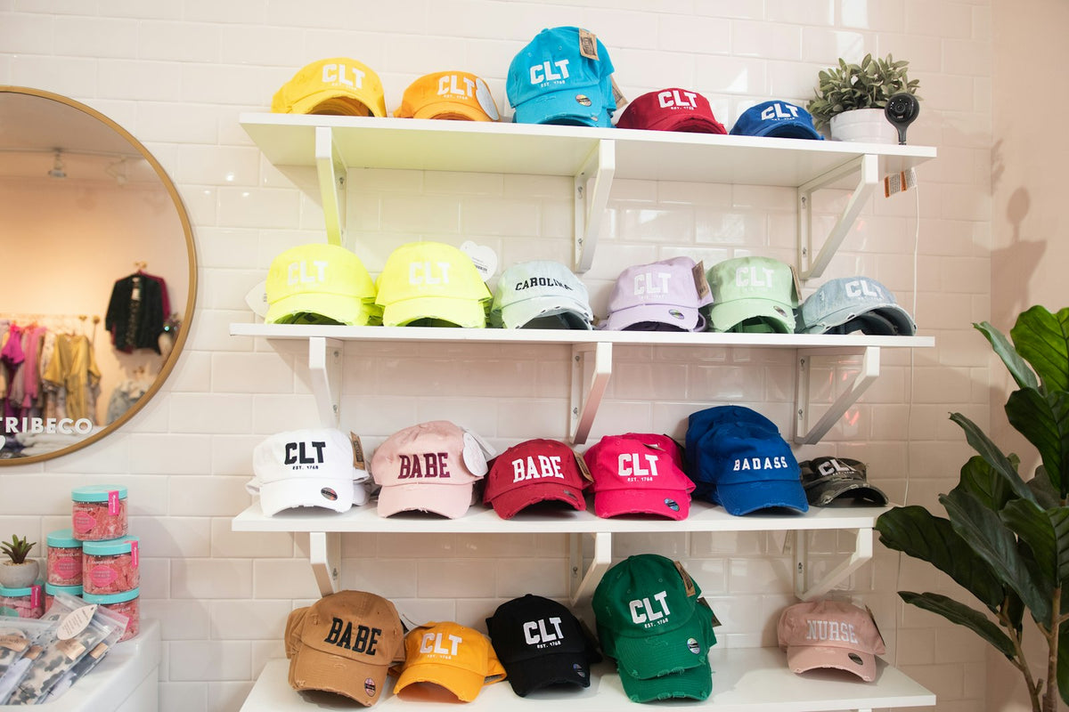 Colección de gorras acomodadas de frente en repisas
