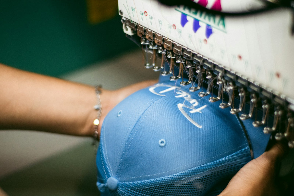 Máquina bordando una gorra trucker azul